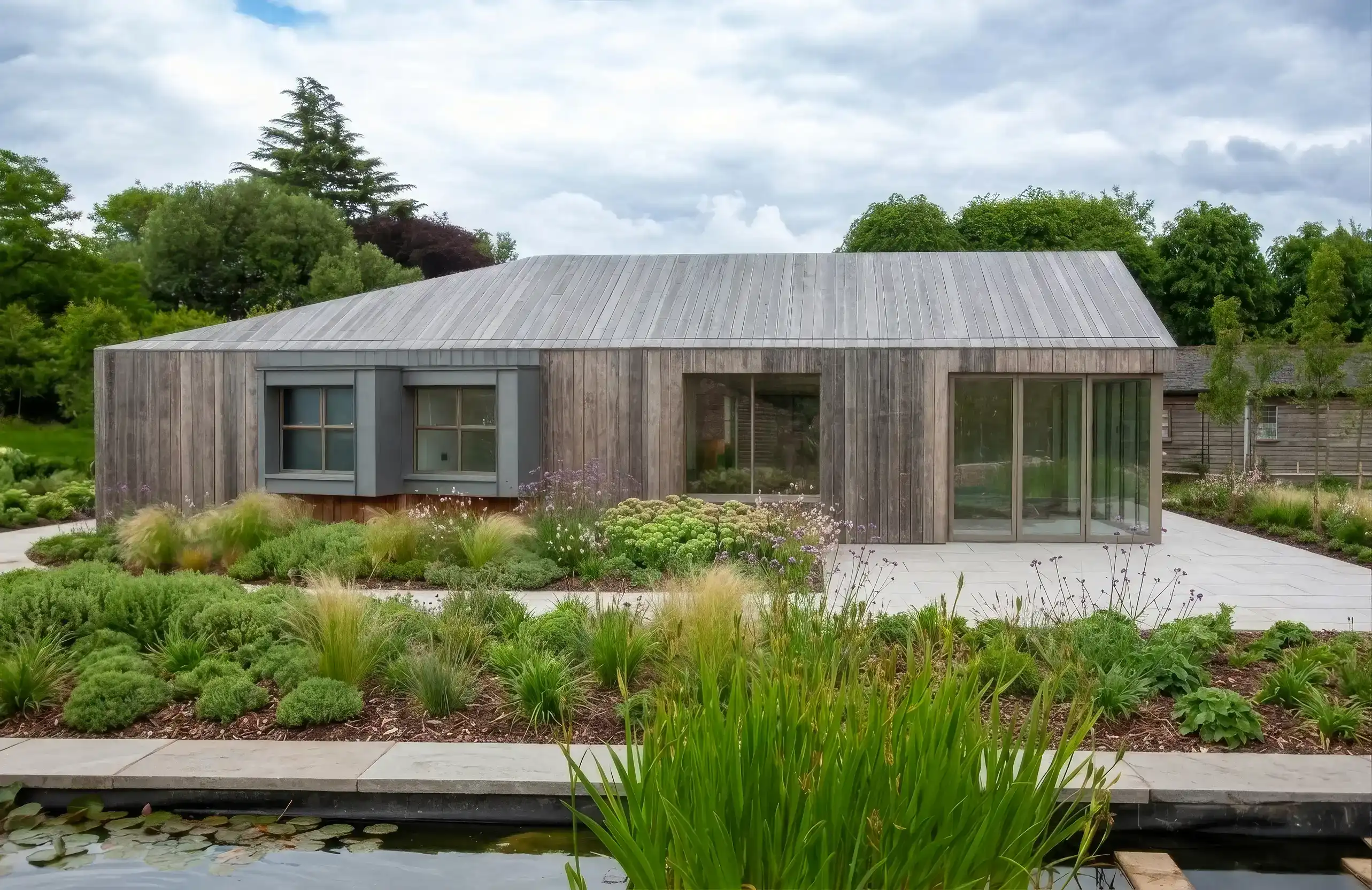 Kebony-clad outbuilding with continuous timber skin extending from wall to roof