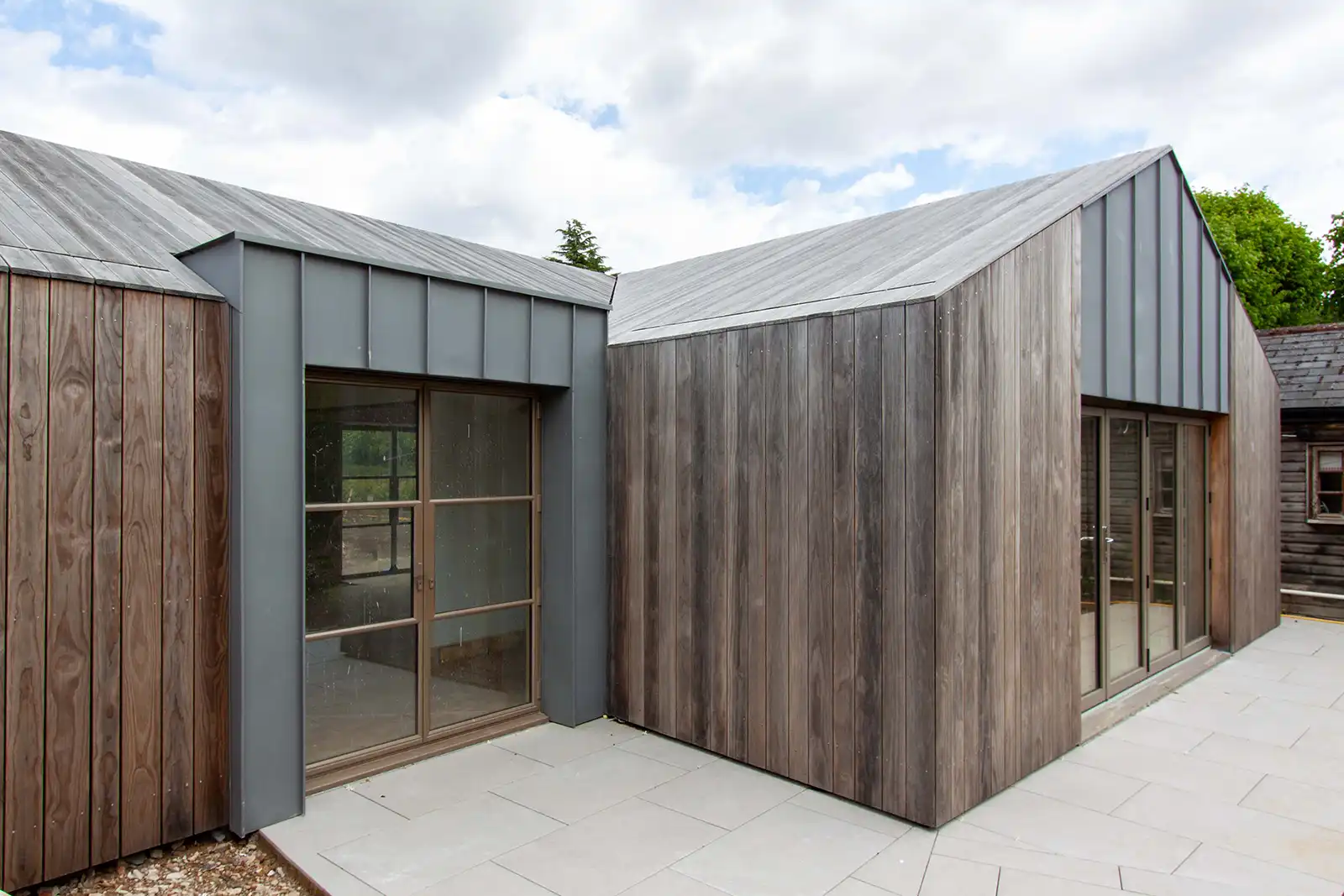 Contemporary timber outbuilding clad in Kebony with standing seam zinc detailing