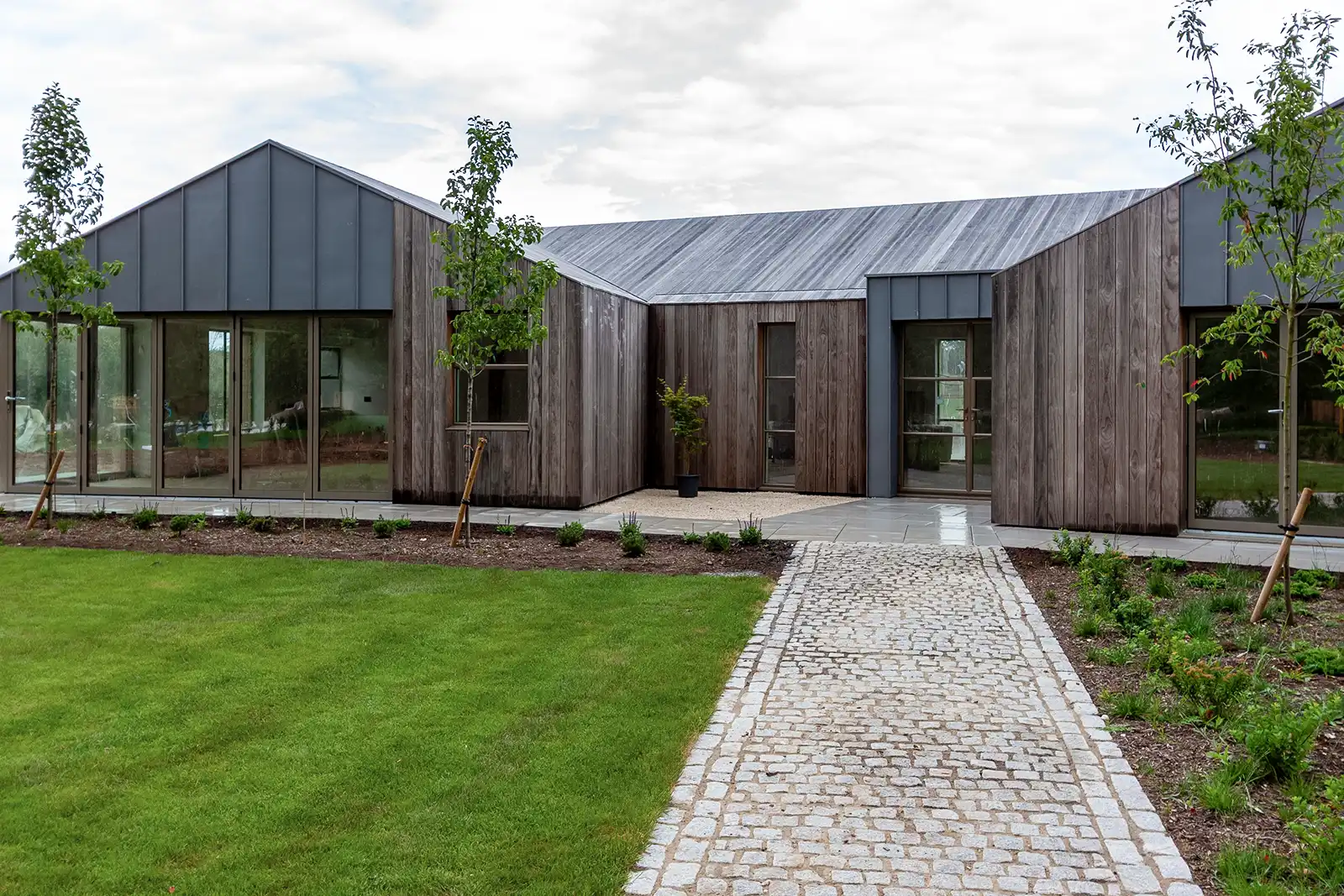 Architectural detail of continuous timber cladding flowing across roof and walls